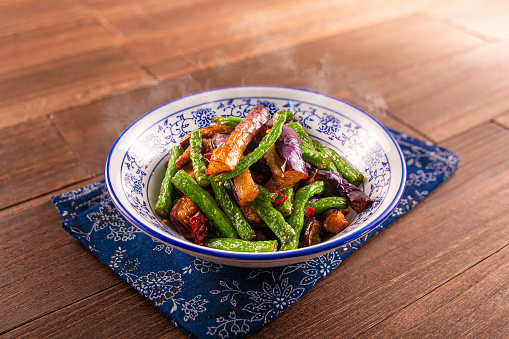 Spicy chilli Hunan Style Eggplant and Green Beans served dish isolated on wooden table top view of Hong Kong food