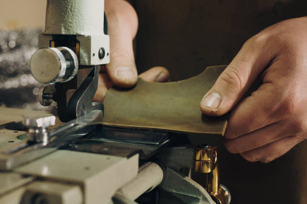 istock leather processing. Cropped view of the man working with leather on equipment 1459150073