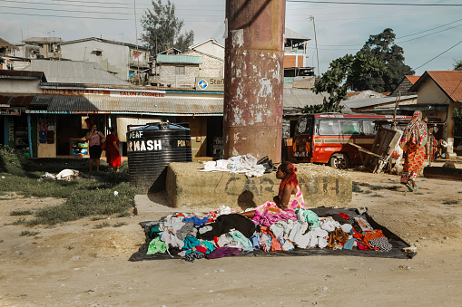 DIani Mombasa Kenya 18 oktober 2019 . young african girl sells clothes in the market sitting on the ground near the road. life in Kenya