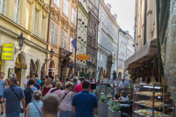 Prague narrow street with people walking around.