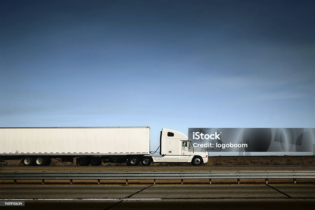 White truck on the road under blue sky White freight truck driving on freeway under blue sky. Truck Stock Photo