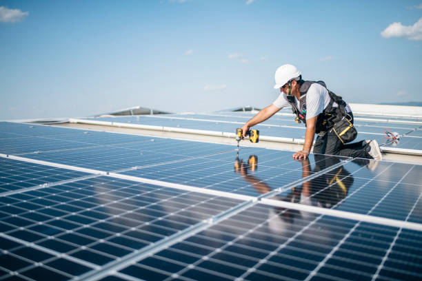 istock Man with drill screwdriver installs panels at a solar power plant. 1459157549