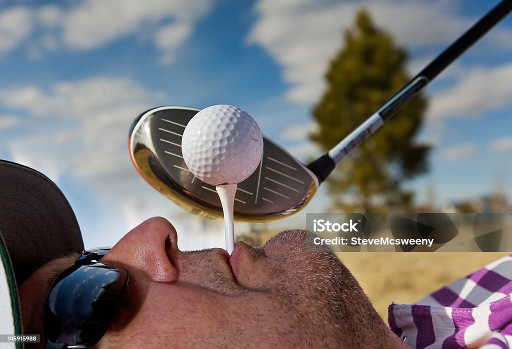 Human Golf Tee A golfer holding a tee in his mouth Humor Stock Photo