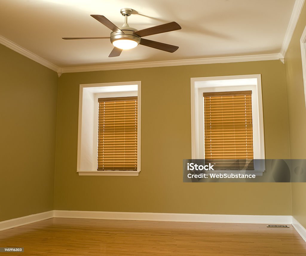Empty room Empty room with dormer windows, hardwood flooring and moldings. Ceiling Fan Stock Photo