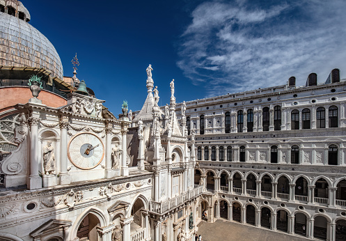 The suggestive and detailed view over the rooftops of Rome from the terrace of the monumental staircase of Trinità dei Monti, better known as Spanish Steps, in the historic and baroque heart of the Eternal City. In the foreground the dome of the Basilica of Santi Ambrogio e Carlo, along Via del Corso, behind the majestic dome of St. Peter's Basilica on the horizon. In 1980 the historic center of Rome was declared a World Heritage Site by Unesco. Image in 16:9 and high definition format.