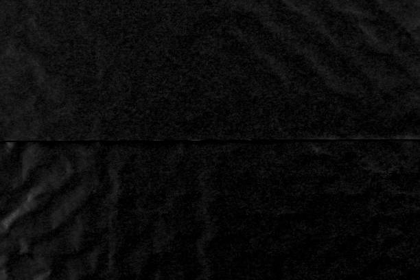 istock Crumpled black paper background cut in half 1459166191