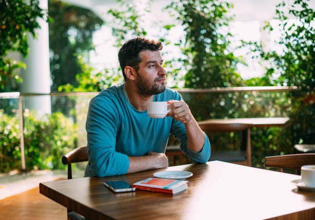 istock Young Man Reading a Book at Cafe 1459168284