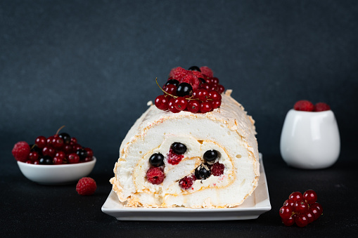 Meringue roll cake with cream and berries. Roulade, summer dessert. Confectionery dessert