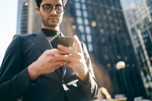 istock Serious hipster messaging on mobile in street 1459168972