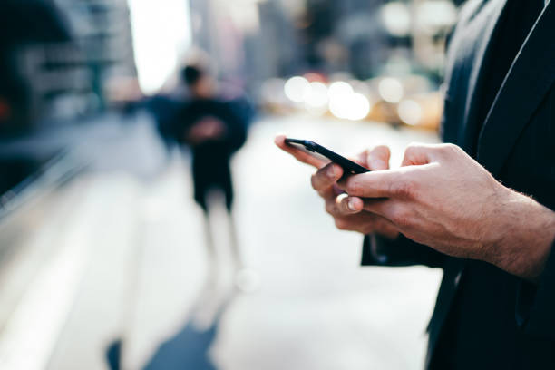 istock Faceless man browsing mobile in street 1459169044