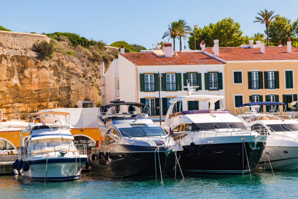 Luxury yachts moored in front of a fortress at the port of Mahon, Menorca, Balearic Islands, Spain stock photo
