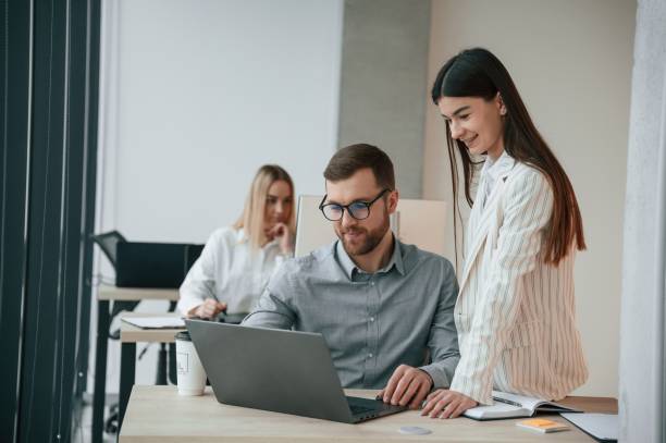 istock Silver colored laptop is on the table. Successful team are working together in the office. Conception of business 1459169274