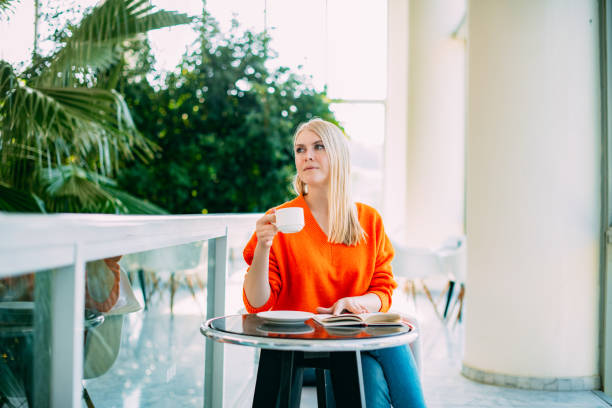 istock Beautiful Blond Woman Drinking Coffee at the Cafe 1459169819