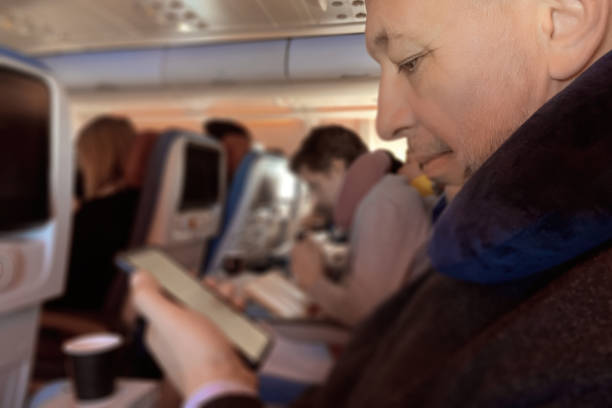 istock Mature man with a phone on a plane 1459170215