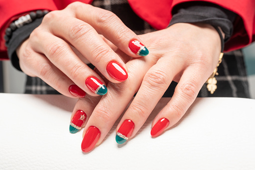 Young woman showing her new red fingernails. After a manicure. Young woman has just gotten a manicure. Beautiful hands and nails. Macro photo. Nail Care.