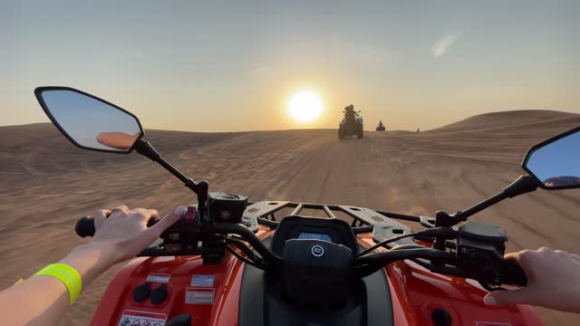 Person riding a motorcycle in the desert - point of view