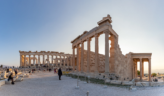 Tourist in casuals with camera exploring ancient Parthenon temple against clear sky