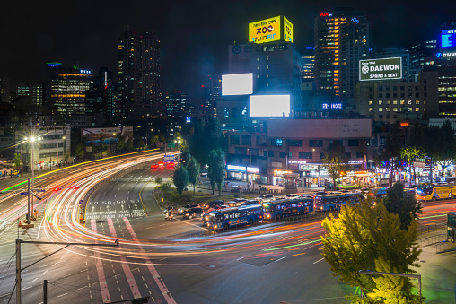 Neon signs and glittering skyscrapers overlooking the zooming traffic highways of central Seoul at night, South Korea’s vibrant capital city.