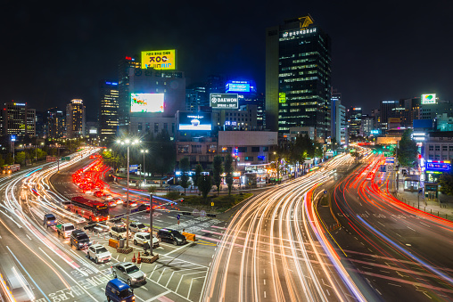 Neon signs and glittering skyscrapers overlooking the zooming traffic highways of central Seoul at night, South Korea’s vibrant capital city.