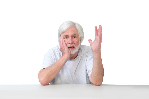 istock Distraught Old man Sitting At Table Gesturing Isolated On White 1459175748