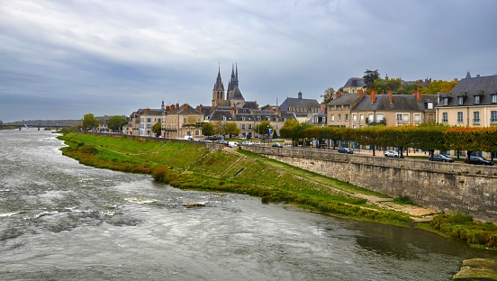 Blois, France, October 28, 2020: View of the northern bank of the Loire River in Blois in the fall. On the horizon there is the St. Nicholas Church. The Loire Valley is listed as UNESCO World Heritage Site.