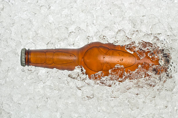 Bottle of cold beer on the snow. Close up view.