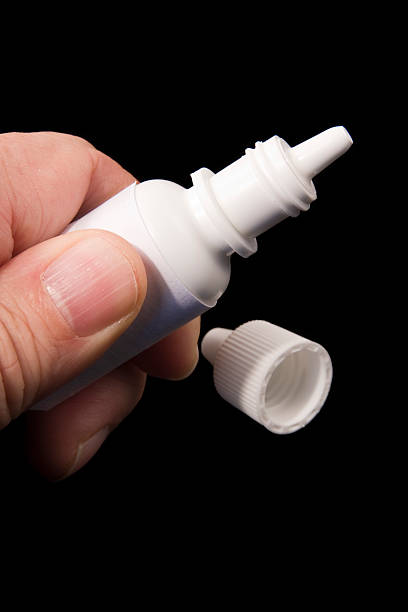 istock Fingers squeezing an eyedrop bottle on black background 145917724