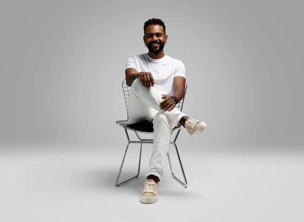 istock Handsome young african american guy sitting on stool, posing in studio - isolated 1459177415