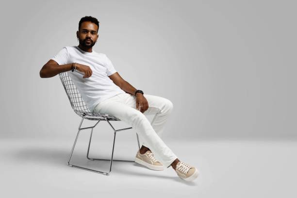 istock Handsome young african american guy sitting on stool, posing in studio - isolated 1459177428
