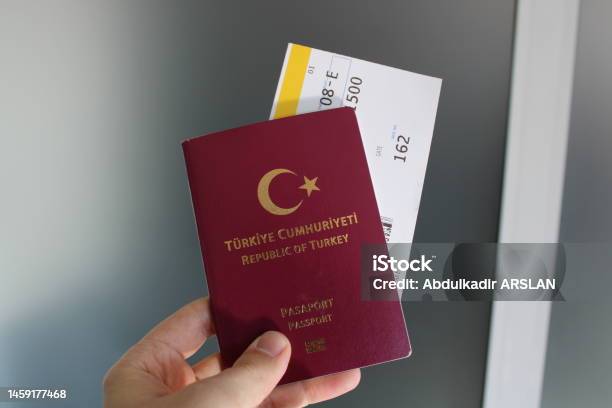 Turkish Burgundy Passport And Flight Ticket In The Passengers Hand Stock Photo - Download Image Now