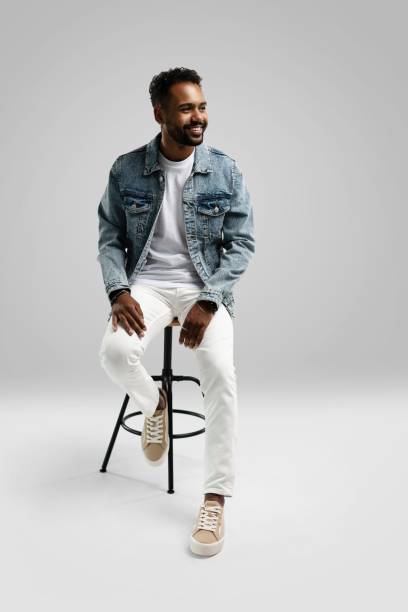 istock Handsome young african american guy sitting on stool, posing in studio - isolated 1459177472