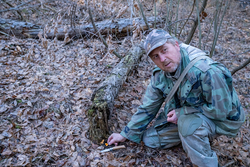 A mushroom picker in green camouflage clothing.