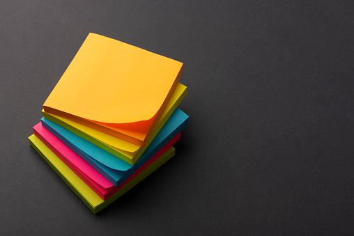 A stack of office stickers in bright colors on a gray table