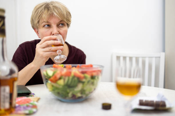istock Mature woman drinking while waiting for dinner in the kitchen. 1459179658