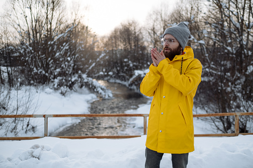 Pleasant thoughts. weather forecast. human and nature. man walking snowy landscape in sunset. travel and expedition concept. man in red parka. winter male fashion. warm clothes for cold climate
