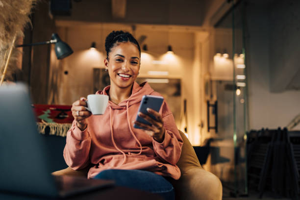 istock Cheerful African businesswoman using a mobile phone, looking at the camera. 1459181086
