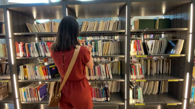 Mid adult woman searching books at the library