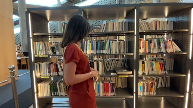 Mid adult woman walking in the library
