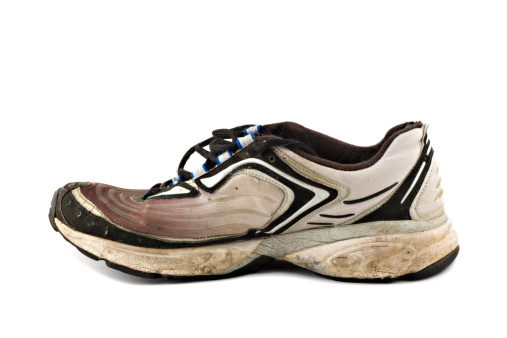 Old grungy Running Shoes isolated on white background