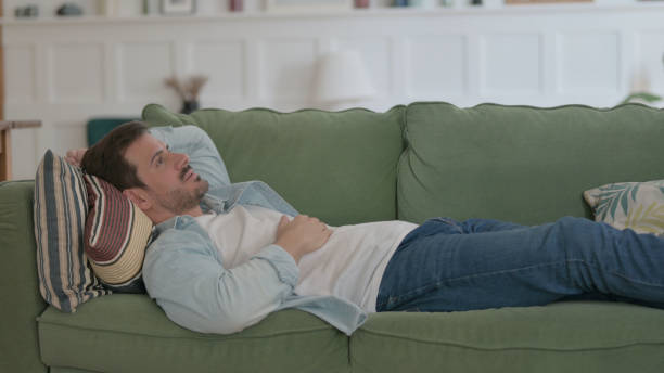 istock Frustrated Young Man Lying on Sofa in Stress 1459182663