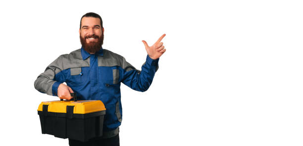 istock Handsome engineer is holding yellow black case for tools and pointing up. 1459182669
