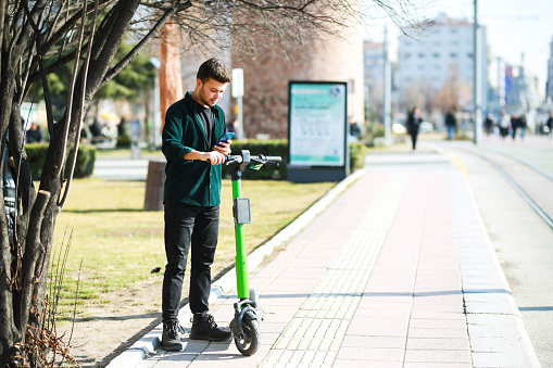 Young man renting a scooter in the city. city ​​tour concept