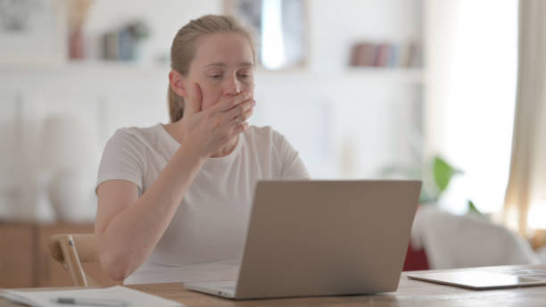 istock Beautiful Young Woman Reacting to Loss While using Laptop 1459183868