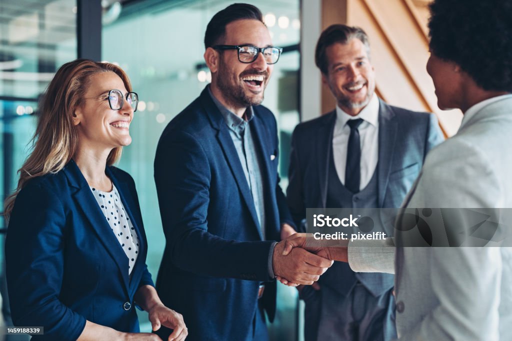 Finding new partners Group of business persons shaking hands in the office Business Stock Photo