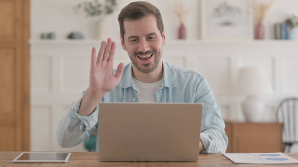 istock Young Man Talking on Video Call on Laptop in Office 1459189622