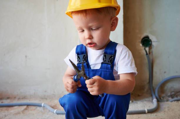 istock Cute child builder holding pliers at construction site. 1459189714