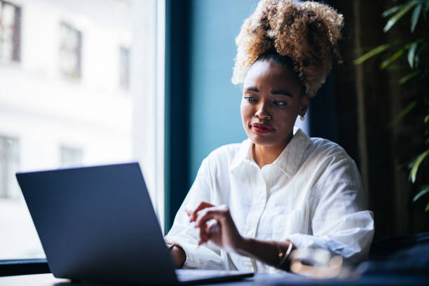 istock Smiling Businesswoman Using A Laptop Computer In The Cafe 1459190323