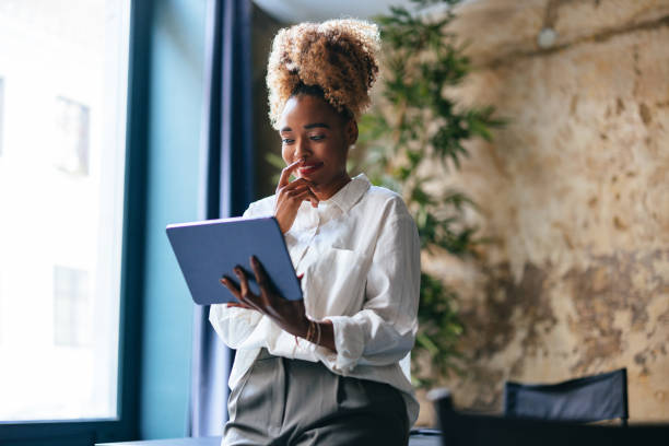 istock Smiling Businesswoman Using A Digital Tablet In Her Office 1459190402