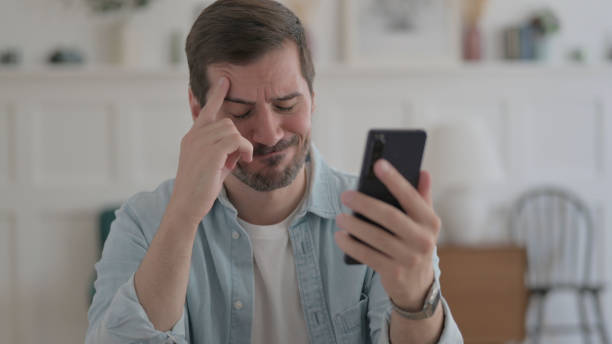 istock Young Man Reacting to Loss on Smartphone 1459190423