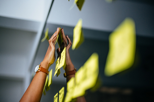 An anonymous African-American  businesswoman making a business plan using sticky notes in the office.